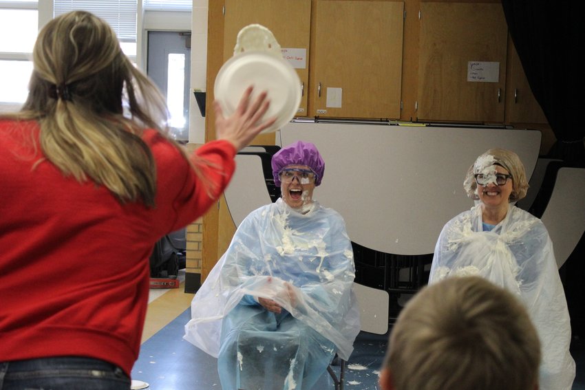 Welchester Elementary School Assistant Principal Jennine Tarpley, center, and Principal Bethany Robinson, far right, are hit with a serving of whipped cream during a Dec. 2 assembly. The two students and teacher who sold the most pastries during a recent fundraiser won the honor of "pieing" Tarpley and Robinson.